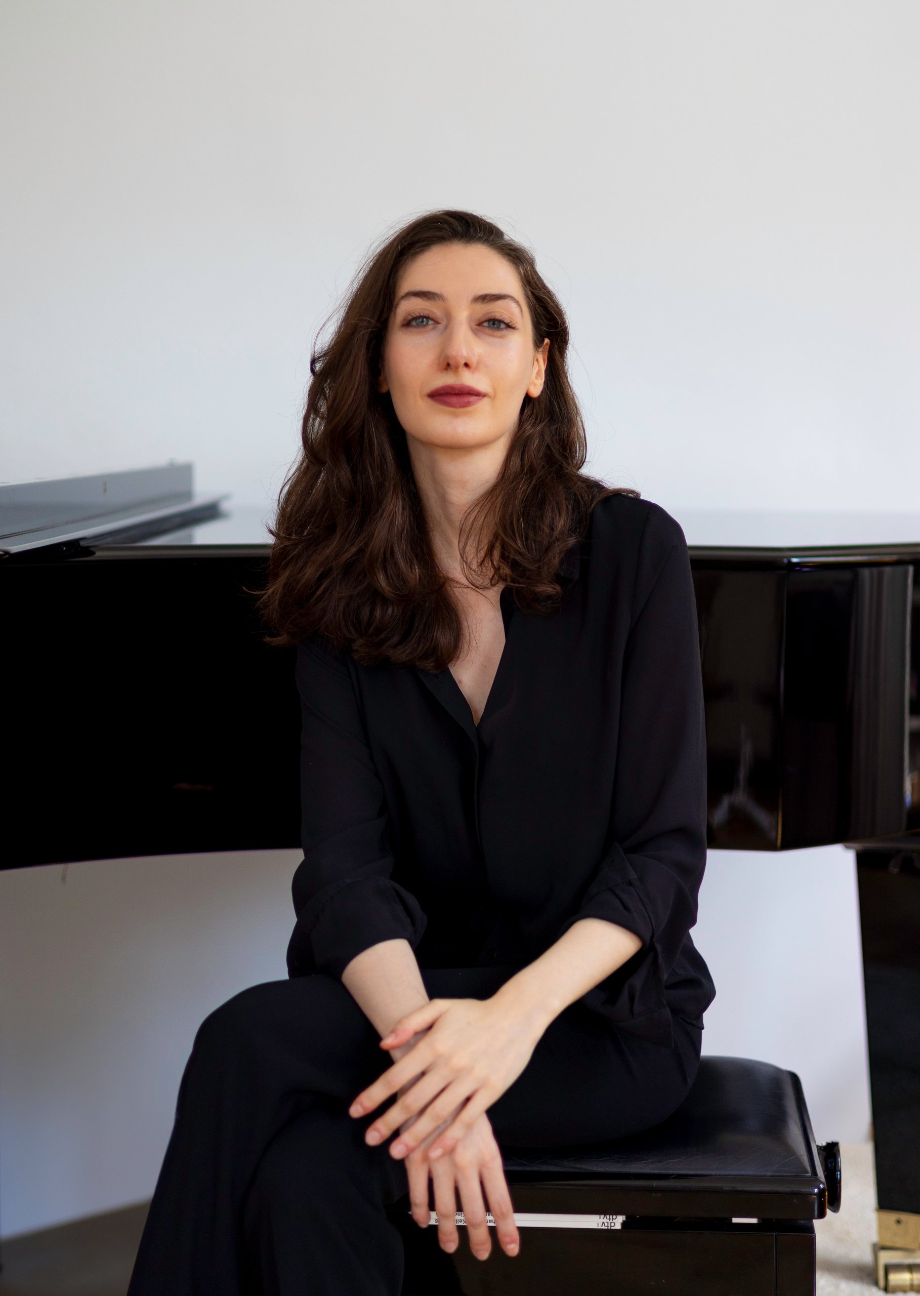 Irma Gigani seated in front of a grand piano
