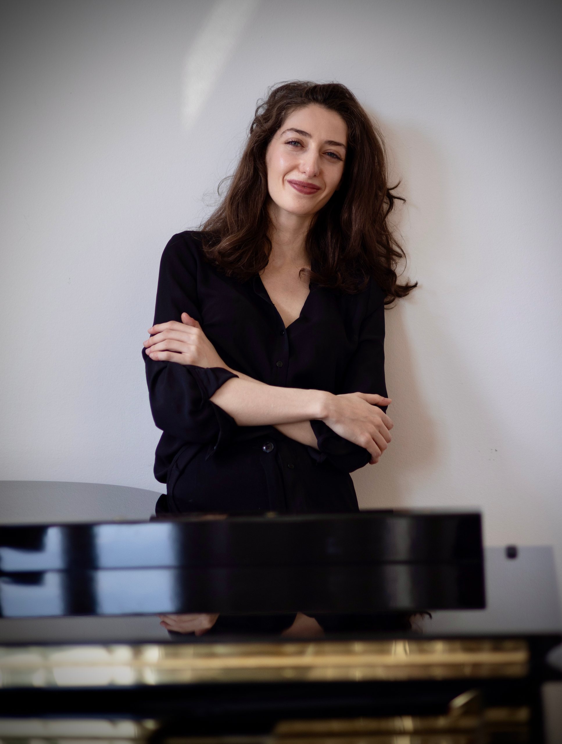 Irma Gigani at the piano, smiling