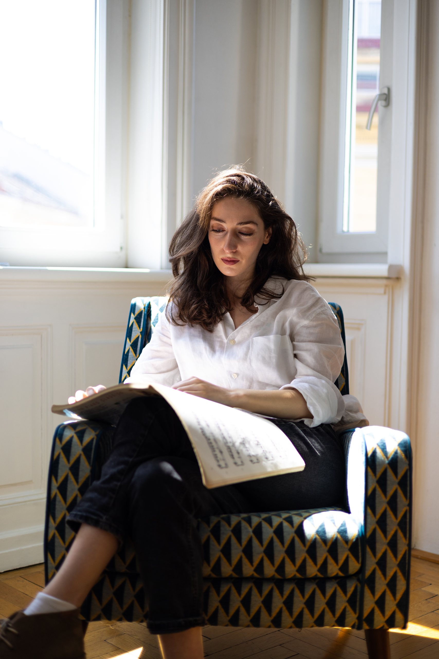 Irma Gigani reading a score in an armchair